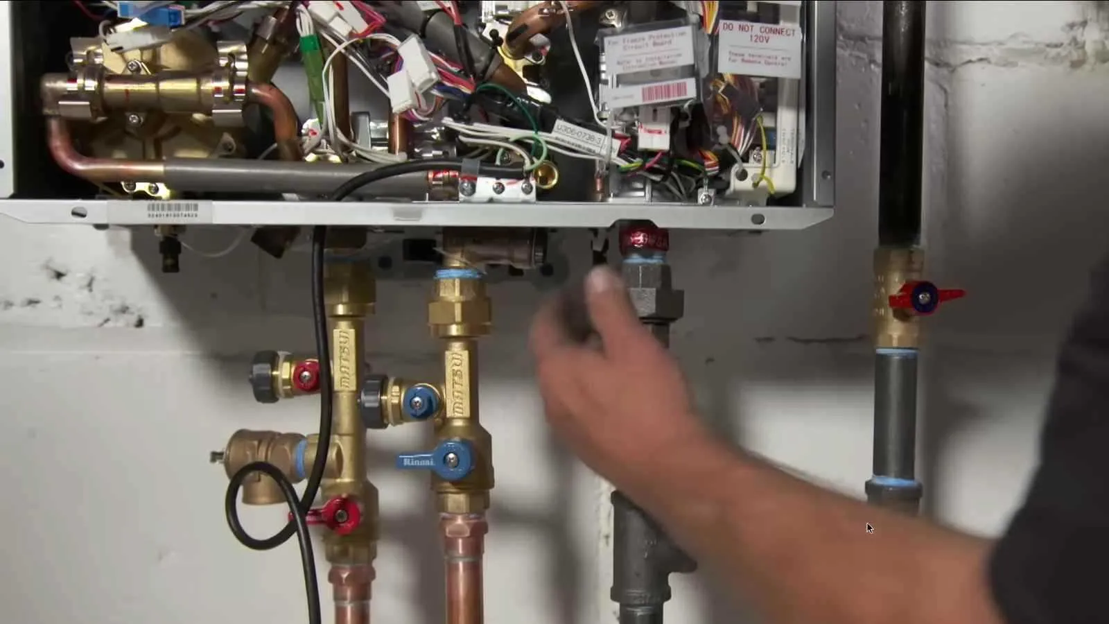 Tankless water heater unit mounted on a basement wall