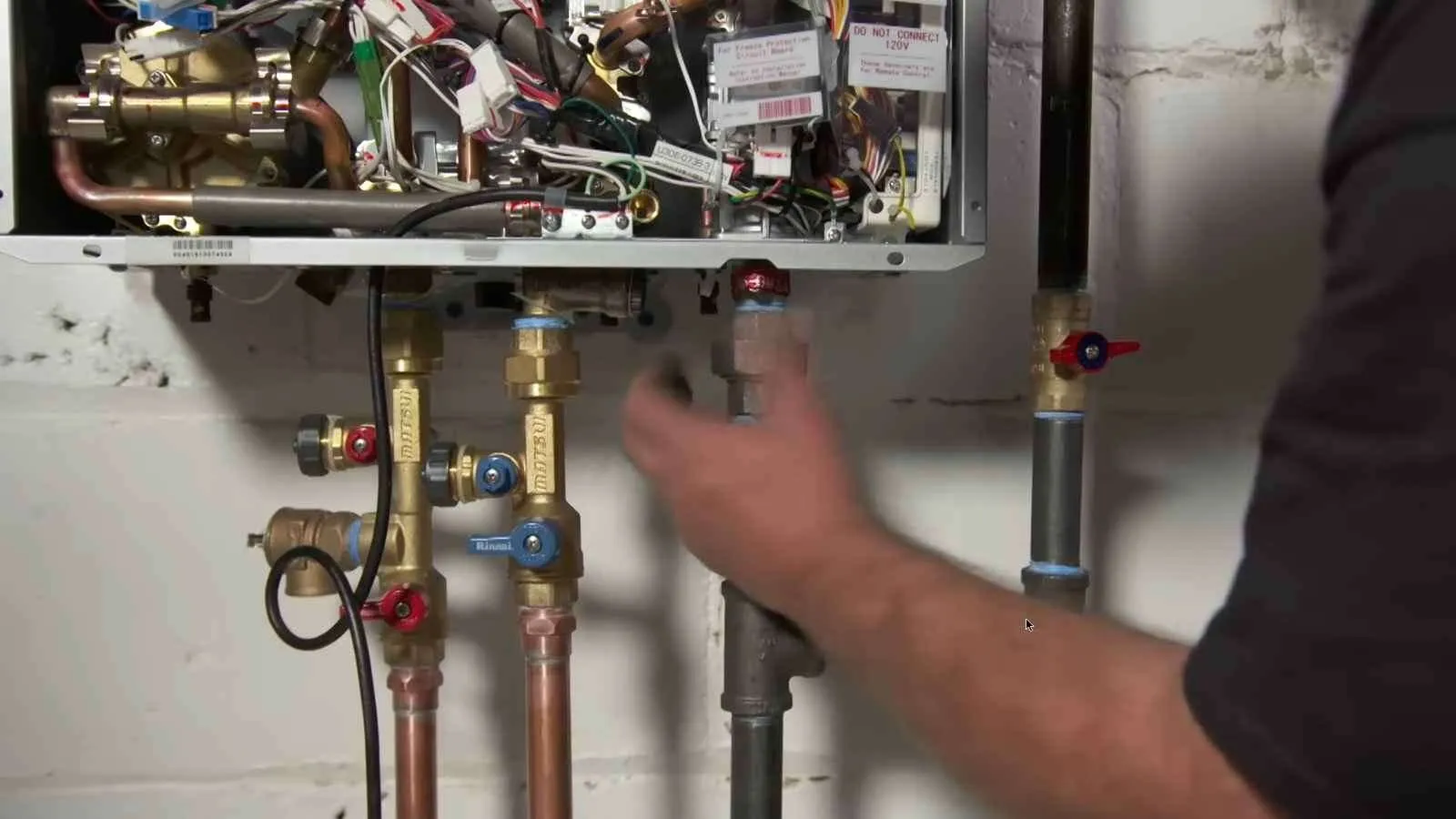 New tankless water heater mounted on a basement wall