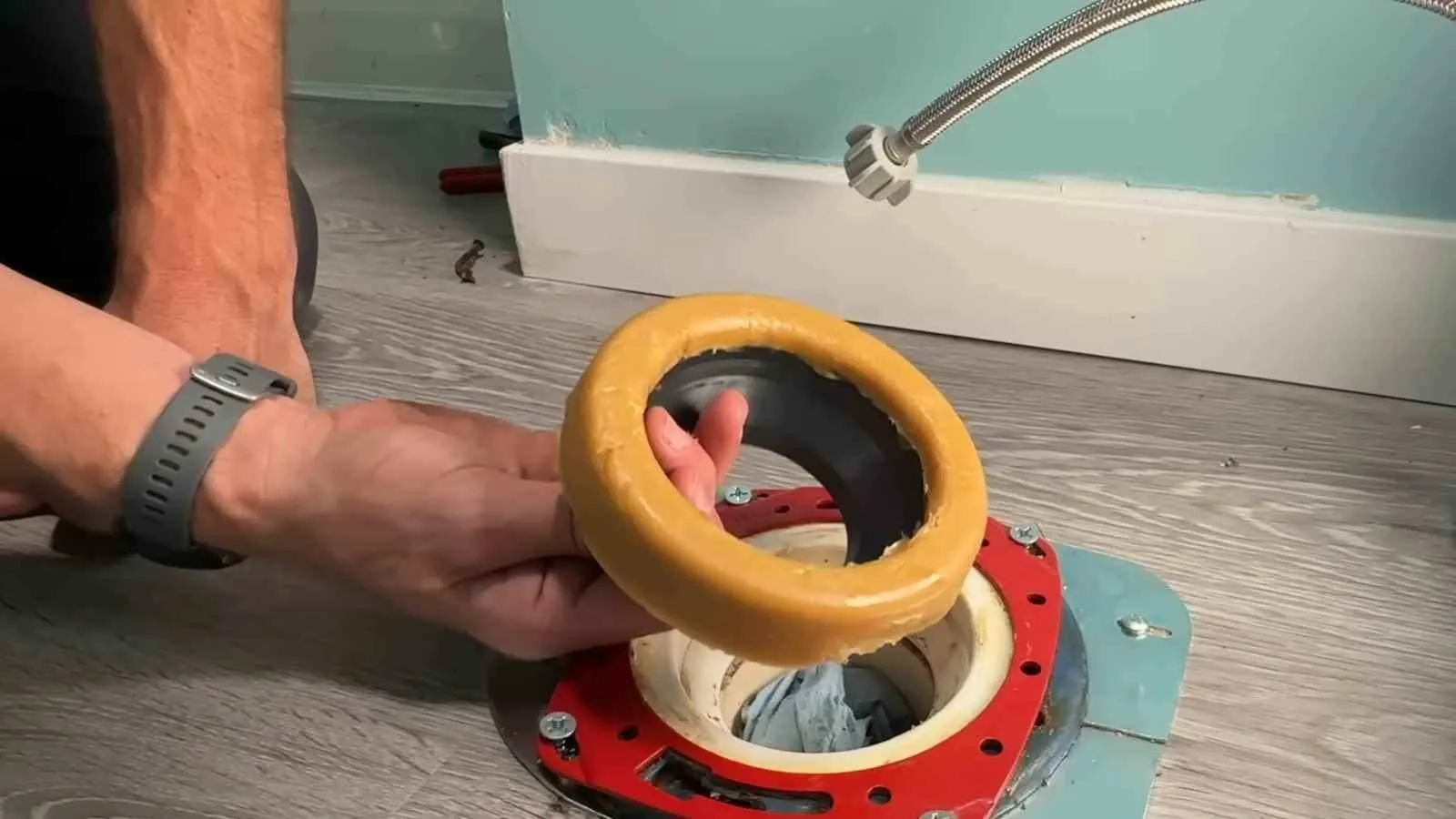 Wax ring being fitted to a toilet bowl outlet