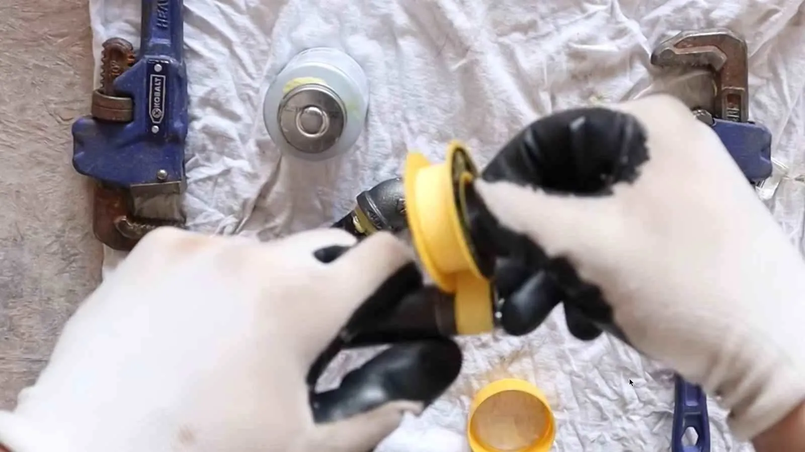 Yellow thread-seal tape wrapped on a black iron gas fitting