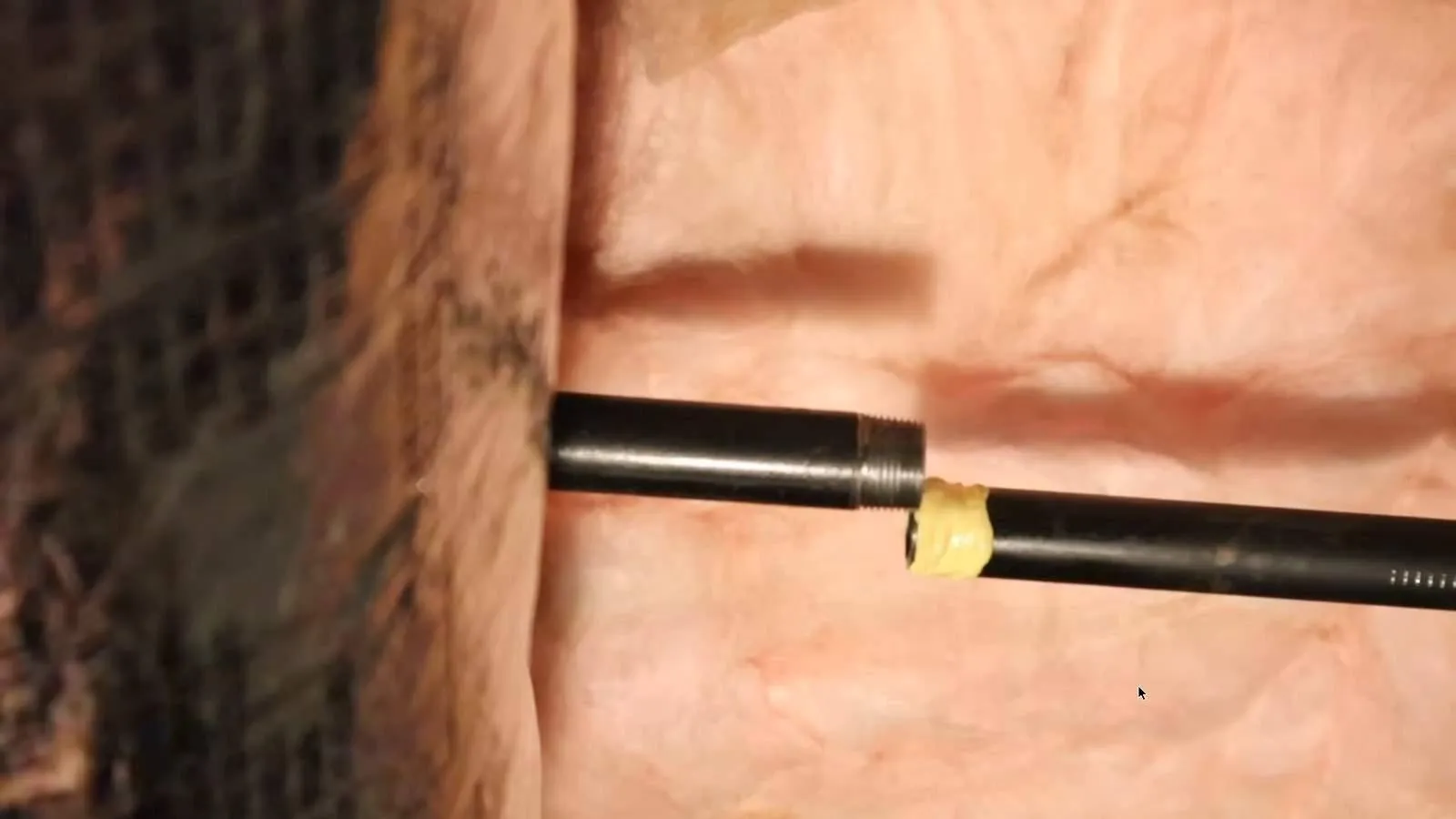 Black iron gas pipe ends joined inside a wall cavity